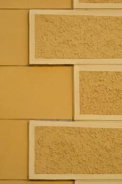 Yellow Building Facade with Rectangular Decorative Elements Stock Photos
