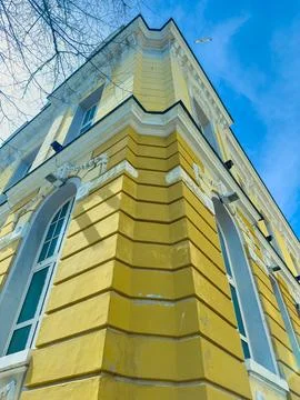 A yellow building is shown from a low angle. The view captures the corner of  Foto stock