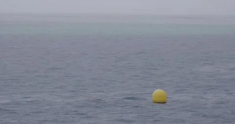 Yellow Buoy Bobs in Rough Seas off the Coast of Tahiti on a Rainy Day Stock Footage 315318622