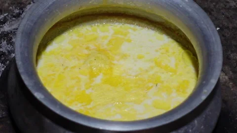Yellow butter or ghee is floating on top of milk Stock Footage 341698870