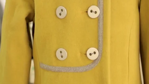 The yellow button on the coat Vídeos de archivo 69147023