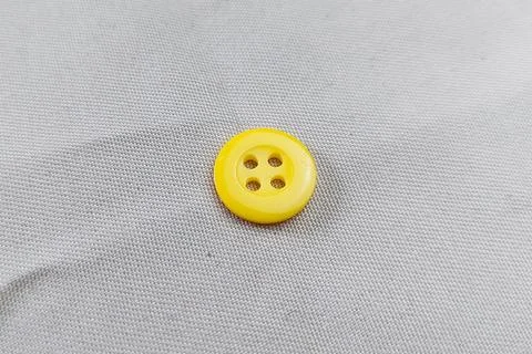 A Yellow Button on the fabric texture Stock Photos