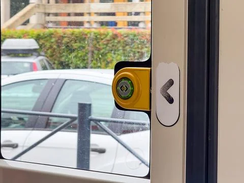Yellow button with green light for tram door opening on glass surface with ar Photos
