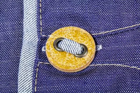 Yellow button on jeans close view Stock Photos