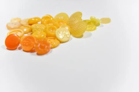 Yellow buttons of different shape and size on the white background. Selective Stock Photos