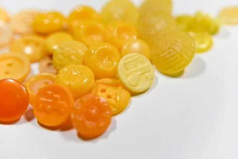 Yellow buttons of different shape and size on the white background. Selective Stock Photos