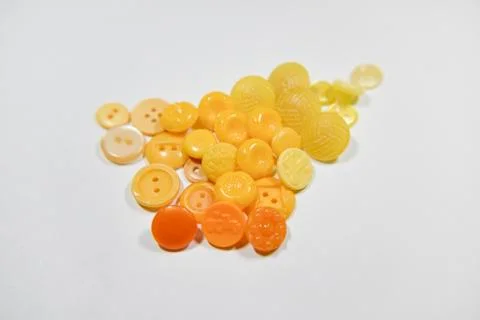 Yellow buttons of different shape and size on the white background. Selective Stock Photos