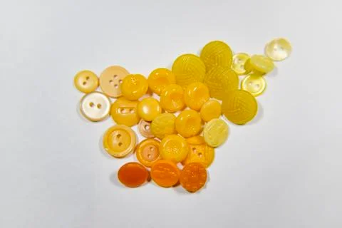 Yellow buttons of different shape and size on the white background. Selective Stock Photos