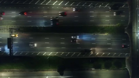 Yellow cab crossing a lit expressway after dark 스톡 동영상 78921407