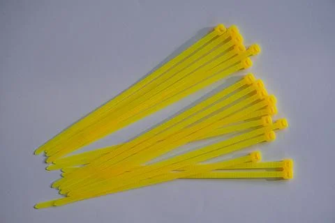 Yellow cable tie, multipurpose fastener, job concept, bond strengthener 스톡 사진
