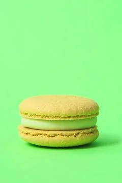 Yellow Cake macaron or macaroon on green background. Stock Photos