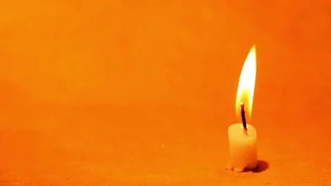 Yellow candle flame lights on a orange background. Stock Footage 183996966