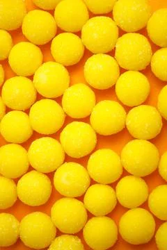 Yellow candy drops in sugar. Background. Stock Photos