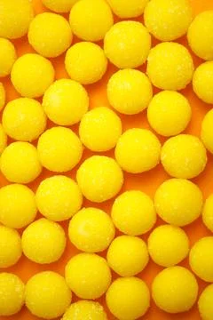 Yellow candy drops in sugar. Background. Stock Photos