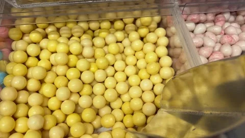 Yellow candy scoop Spoon gathers vibrant sprinkles in close-up view Stock Footage 314097764