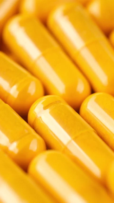 Yellow capsule close up, rotation. Tablets or vitamins in capsules Stock Footage 296482977