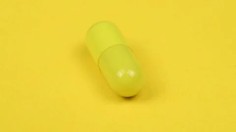 Yellow capsule on white background. Side view. Loop motion. Stock Footage 167059455