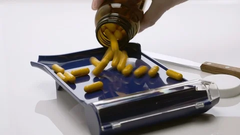 Yellow Capsules Falling from Bottle on a Pharmacist Blue Counting Pills Tray. 4K Stock Footage 121270261