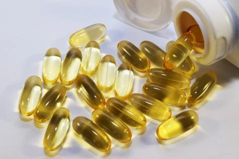Yellow capsules on a white background. Stock Photos