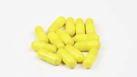 Yellow capsules on white background. Side view. Loop motion. Stock Footage 167058380