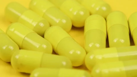 Yellow capsules on white background. Side view. Extrem close-up. Stock Footage 167058940