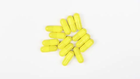 Yellow capsules on white background. Top view. Loop motion. Stock Footage 167057965