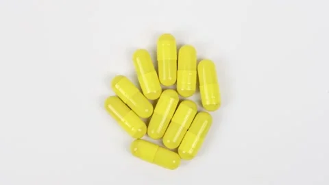 Yellow capsules on white background. Top view. Stock Footage 167072347
