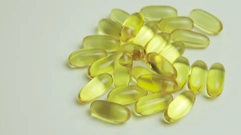 Yellow capsules on a white background. Vitamins for health. Concept of health Stock Footage 132798803