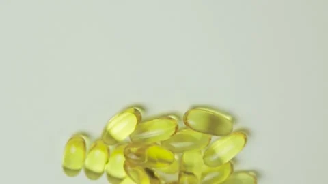 Yellow capsules on a white background. Vitamins for health. Concept of health Stock Footage 135775587