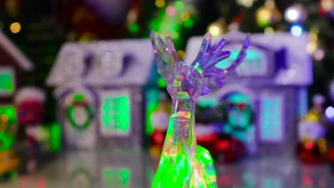 A yellow car with a Christmas tree on its roof drives through a Christmas town Stock Footage 317533657
