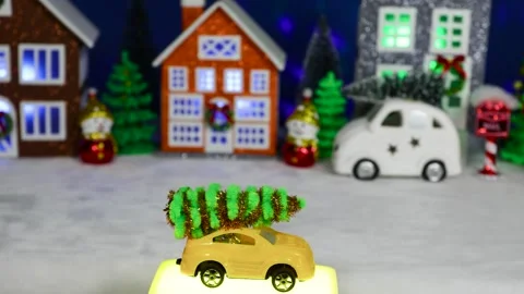 A yellow car moves against the backdrop of a Christmas village Stock Footage 308569491
