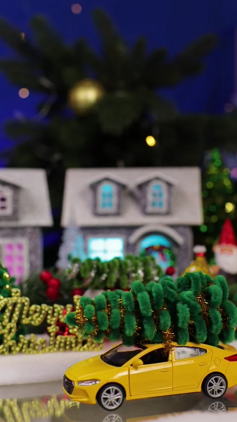 A yellow car past and stops in front of the Christmas village Stock Footage 343849626