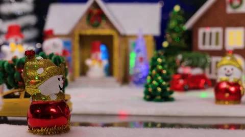 A yellow car quickly drives up to a snowman against of a Christmas village Stock Footage 344876055