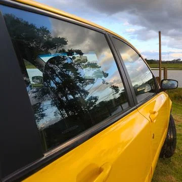 Yellow car with reflections in the window Stock Photos