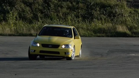 Yellow car screeching around a corner at drifting event. Stock Footage 59746897