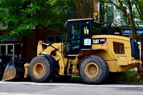 Yellow CAT backhoe under a tree Stock Photos