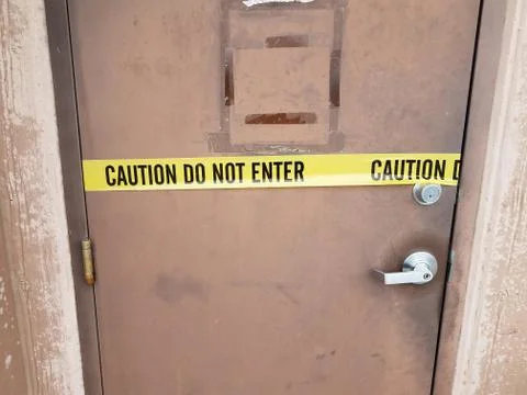 Yellow caution tape do not enter sign on door Stock Photos