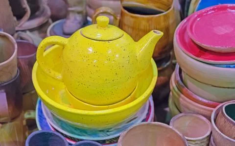 Yellow ceramic teapot on the background of kitchen utensils. Stock Photos