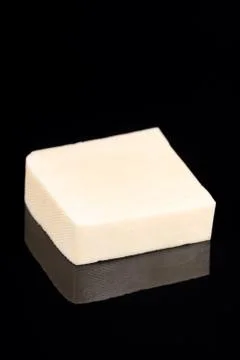 Yellow cheese on the black background with reflections and copy space Stock Photos