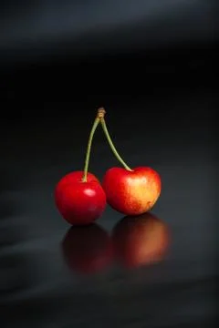 Yellow cherry on black reflective background Stock Photos