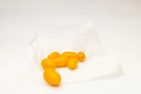 Yellow cherry tomatoes on a white background Stock Photos