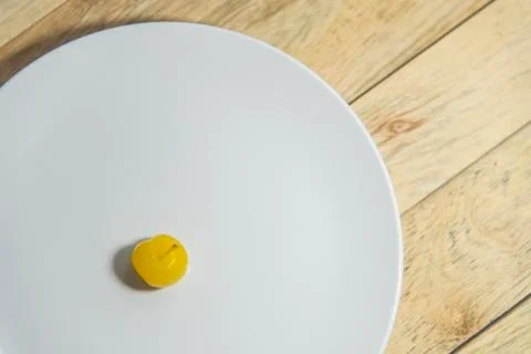 Yellow cherry on white plate Stock Photos