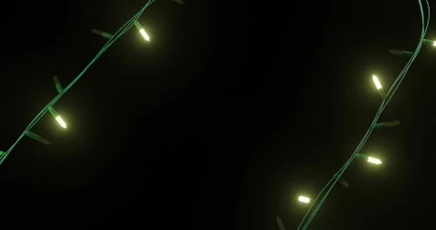 Yellow christmas string lights flashing on black background, copy space Stock Footage 253158374