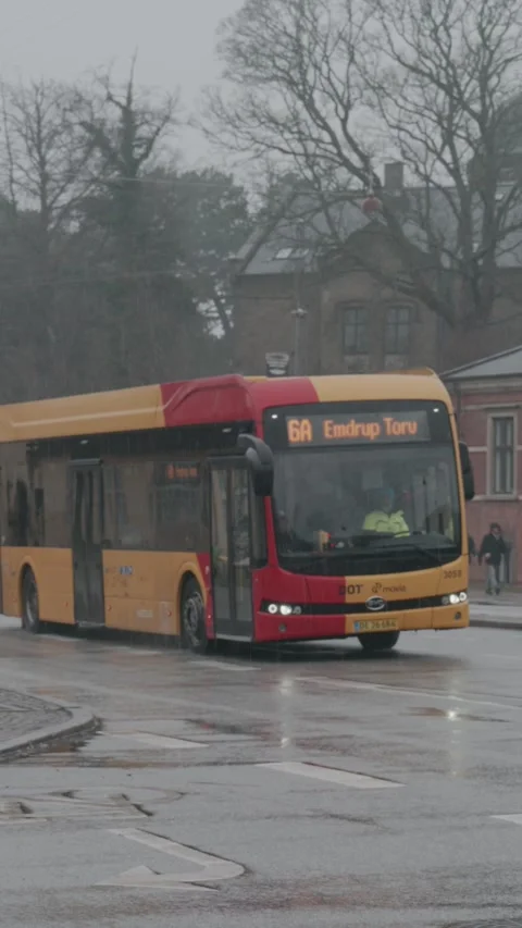 Yellow City Bus Driving Through Rainy Streets in Copenhagen, Denmark Stock Footage 340826443