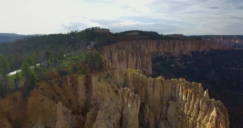 Yellow cliff of a canyon with pine trees, a highway and a white car Vídeo Stock 118643291