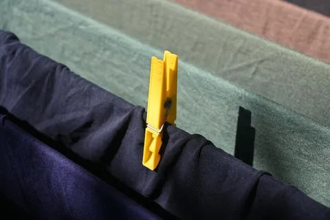 Yellow clothespin securing drying clothes Stock Photos