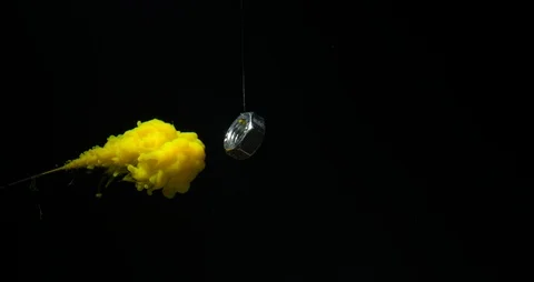 Yellow cloud of ink in water. Surrounding the nut in slow motion Stock Footage 122824791