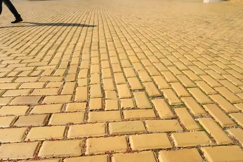 Yellow cobblestone, brick road in Sofia, shadow of pedestrian in the backgrou Stock Photos