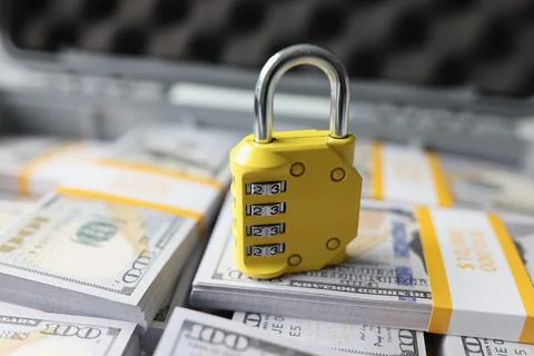 Yellow code lock on dollars in the suitcase, close-up Stock Photos