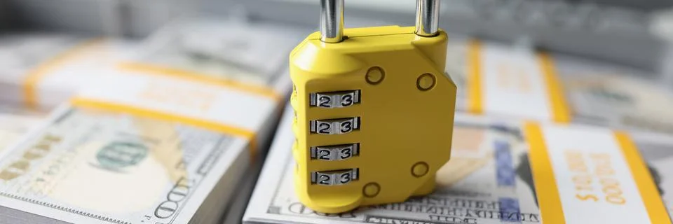 Yellow code lock on dollars in the suitcase, close-up Stock Photos